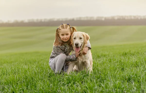 Menina cuddling cão no campo — Fotografia de Stock