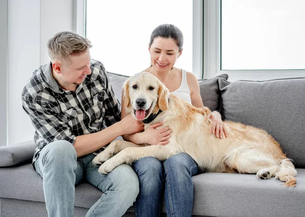 Mujer y hombre abrazando lindo perro — Foto de Stock