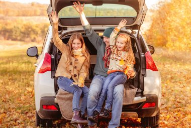 Sonbahar mevsiminde kızları olan baba.