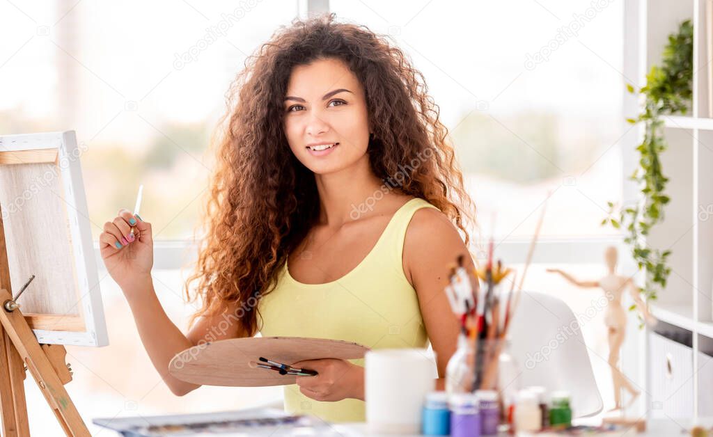 Artist sitting next to easel