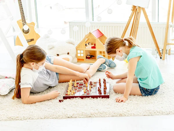 Vackra flickor spelar schack under karantän — Stockfoto