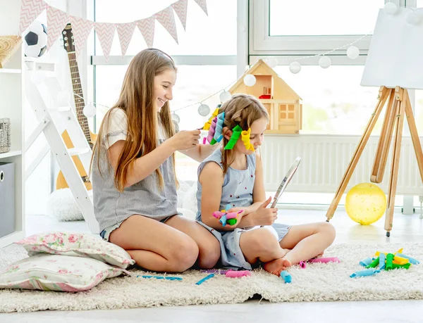 Syster gör frisyr till liten flicka — Stockfoto