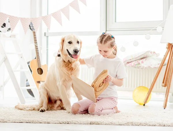 Schattig klein meisje en hond lezen — Stockfoto