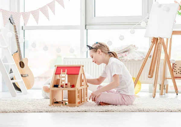 Menina bonita brincando com casa de bonecas — Fotografia de Stock