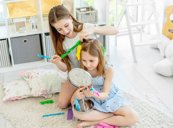 Irmã fazendo penteado para menina — Fotografia de Stock