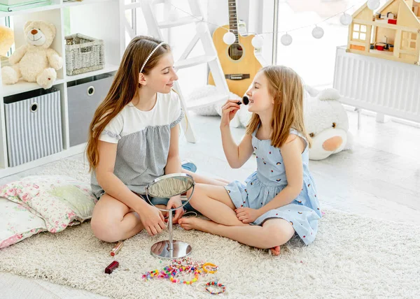 Des enfants souriants appliquent des cosmétiques de maquillage — Photo