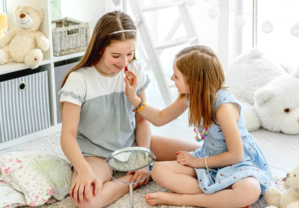 Glada barn leker med makeup läppstift — Stockfoto