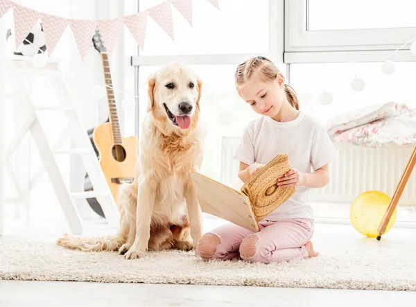 Aranyos kislány és kutya olvasás — Stock Fotó