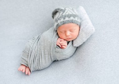 Küçük yastıkta uyuyan yeni doğmuş şirin bir bebek.