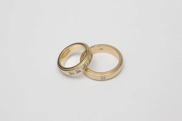 Anéis de casamento em ouro amarelo com diamantes isolados em branco — Fotografia de Stock