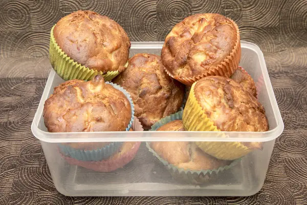 Čerstvé ručně dělané muffiny v průhledný box na tmavé dřevěné pozadí — Stock fotografie