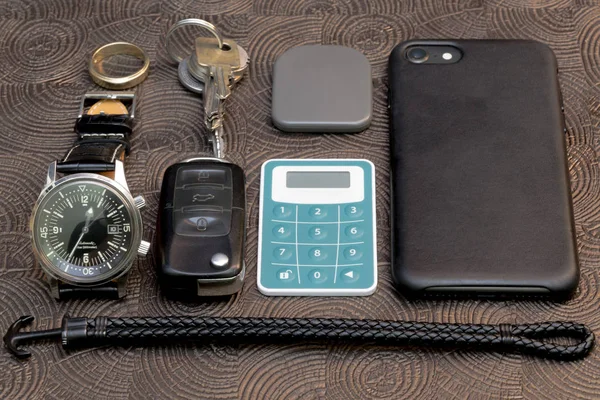 Een zakelijke man lederen accessoires, close-up. Portemonnee, riem, handstrap en mobiele telefoon met geval — Stockfoto