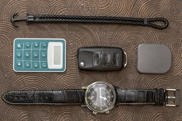Een zakelijke man lederen accessoires, close-up. Portemonnee, riem, handstrap en mobiele telefoon met geval — Stockfoto