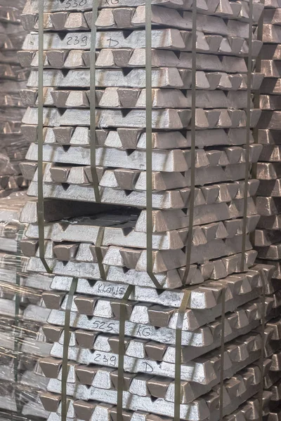 産業の背景として輸出のための屋内倉庫のパレットインゴット貯蔵のアルミニウムのクローズアップ。パレットのアルミニウム地金 ロイヤリティフリーのストック画像