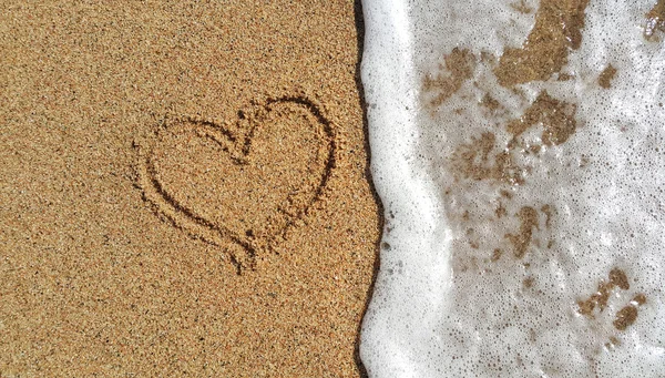 Heart drawing in the sand and sea foam — Stock Photo, Image