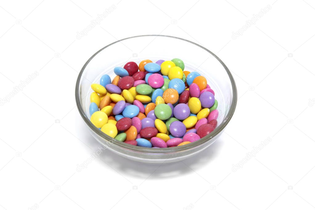 Bright colorful candy in glass bowl on white background