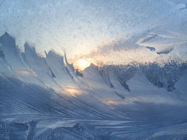 Belo padrão de gelo e luz solar no vidro de inverno — Fotografia de Stock