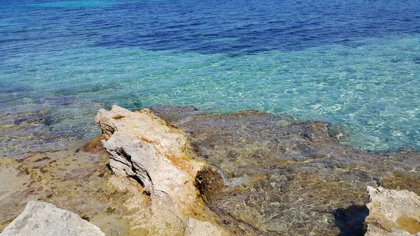 明るいターコイズ ブルーの海の水と沿岸の岩 — ストック写真