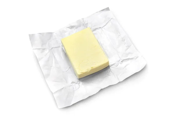 Pedaço de manteiga sobre um fundo branco — Fotografia de Stock