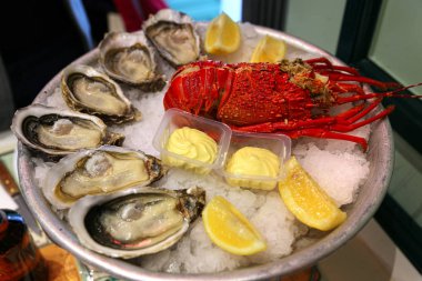 Taze deniz ürünleri ile büyük çanak istiridye ıstakoz limon ve buz üstünde sos ile 