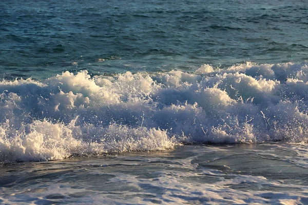 Sea waves and white foam on the evening coast — Stock Photo, Image
