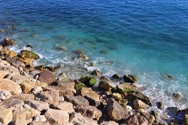 Jasně modrá mořská voda a kamenité pobřeží — Stock fotografie