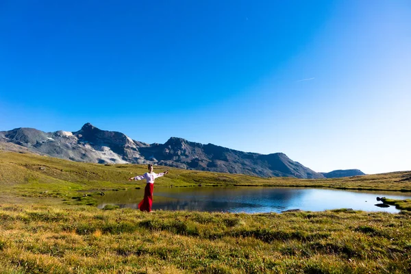 Young girl dancing near lake in mountains. — Stock Photo, Image