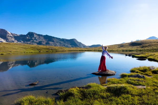 Junges Mädchen tanzt in der Nähe von See in den Bergen. — Stockfoto