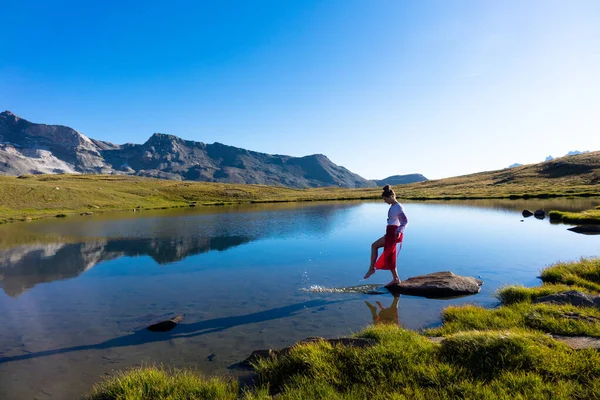 Young girl dancing near lake in mountains. — 스톡 사진