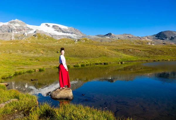 Junges Mädchen tanzt in der Nähe von See in den Bergen. — Stockfoto