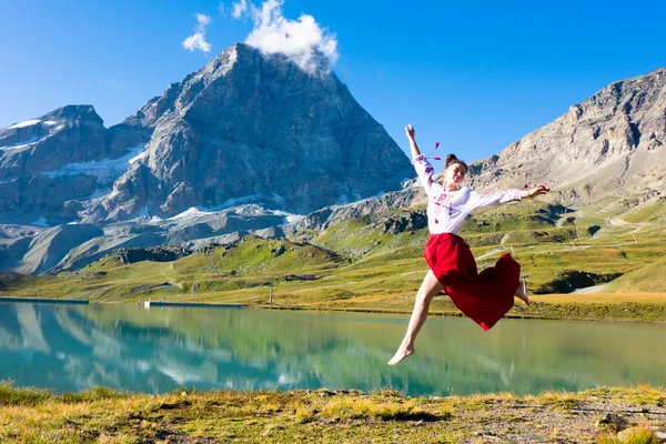 Young girl dancing near lake in mountains. — 스톡 사진