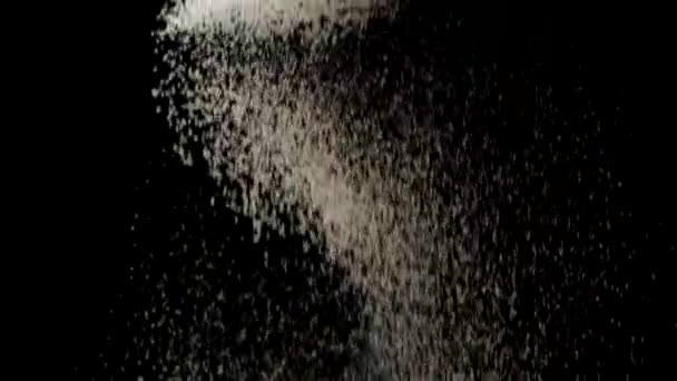 White flour granules falling on black background — Stock Video