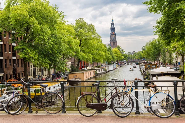 Fietsen op een brug over de grachten van amsterdam — Stockfoto