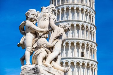 Pisa Kulesi melekler heykeli ile bir yaz günü İtalya'da yaslanmış.