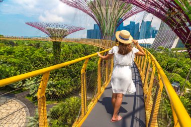 SINGAPORE - 23 Haziran 2019 Singapur Körfezi yakınlarındaki Gardens 'taki Skyway Köprüsü' nde beyaz elbise ve hasır şapka giyen kadın gezgin