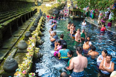 BALI, INDONEZYA - 28 Şubat 2020: Bali halkı Endonezya 'nın Bali kentindeki Pura Tirta Empul Tapınağı' ndaki kutsal havuzda dua ediyor