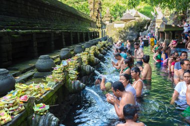 BALI, INDONEZYA - 28 Şubat 2020: Bali halkı Endonezya 'nın Bali kentindeki Pura Tirta Empul Tapınağı' ndaki kutsal havuzda dua ediyor