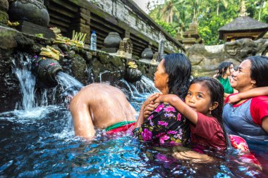 BALI, INDONEZYA - 28 Şubat 2020: Bali halkı Endonezya 'nın Bali kentindeki Pura Tirta Empul Tapınağı' ndaki kutsal havuzda dua ediyor