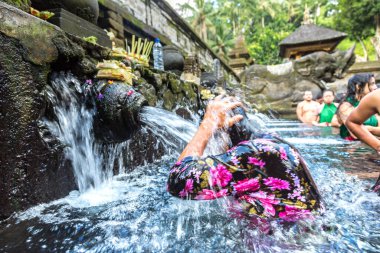 BALI, INDONEZYA - 28 Şubat 2020: Bali halkı Endonezya 'nın Bali kentindeki Pura Tirta Empul Tapınağı' ndaki kutsal havuzda dua ediyor