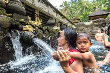 BALI, INDONEZYA - 28 Şubat 2020: Bali halkı Endonezya 'nın Bali kentindeki Pura Tirta Empul Tapınağı' ndaki kutsal havuzda dua ediyor