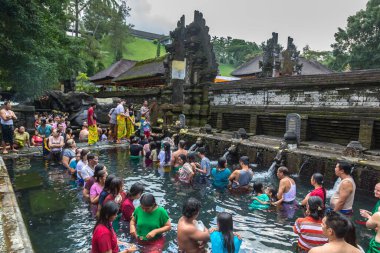 BALI, INDONEZYA - 28 Şubat 2020: Bali halkı Endonezya 'nın Bali kentindeki Pura Tirta Empul Tapınağı' ndaki kutsal havuzda dua ediyor