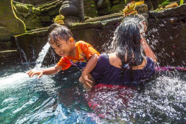 BALI, INDONEZYA - 28 Şubat 2020: Bali halkı Endonezya 'nın Bali kentindeki Pura Tirta Empul Tapınağı' ndaki kutsal havuzda dua ediyor