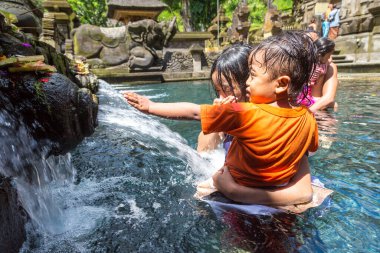 BALI, INDONEZYA - 28 Şubat 2020: Bali halkı Endonezya 'nın Bali kentindeki Pura Tirta Empul Tapınağı' ndaki kutsal havuzda dua ediyor