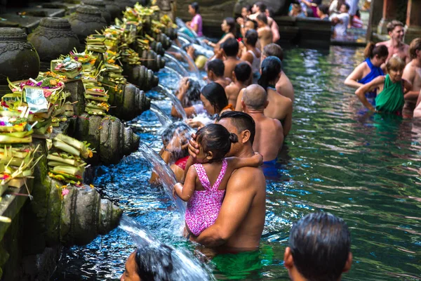 BALI, INDONEZYA - 28 Şubat 2020: Bali halkı Endonezya 'nın Bali kentindeki Pura Tirta Empul Tapınağı' ndaki kutsal havuzda dua ediyor