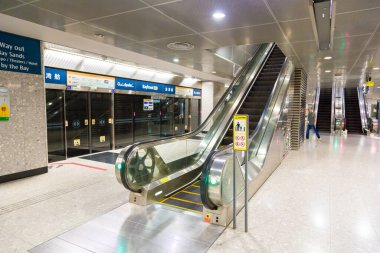 SINGAPORE, SINGAPORE - 26 Şubat 2020: Modern istasyon platformu ve MRT metro istasyonundaki yürüyen merdivenlere bakın
