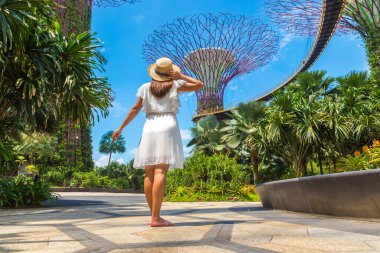 SINGAPORE - 23 Haziran 2019 Singapur Körfezi yakınlarındaki Gardens 'ta beyaz elbise ve hasır şapka giyen kadın gezgin