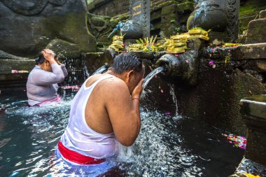 BALI, INDONEZYA - 28 Şubat 2020: Bali halkı Endonezya 'nın Bali kentindeki Pura Tirta Empul Tapınağı' ndaki kutsal havuzda dua ediyor