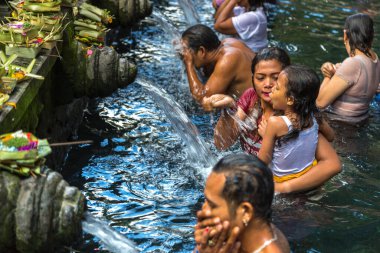 BALI, INDONEZYA - 28 Şubat 2020: Bali halkı Endonezya 'nın Bali kentindeki Pura Tirta Empul Tapınağı' ndaki kutsal havuzda dua ediyor