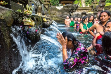 BALI, INDONEZYA - 28 Şubat 2020: Bali halkı Endonezya 'nın Bali kentindeki Pura Tirta Empul Tapınağı' ndaki kutsal havuzda dua ediyor