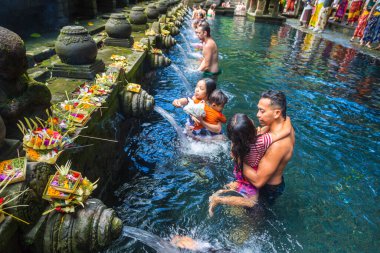 BALI, INDONEZYA - 28 Şubat 2020: Bali halkı Endonezya 'nın Bali kentindeki Pura Tirta Empul Tapınağı' ndaki kutsal havuzda dua ediyor